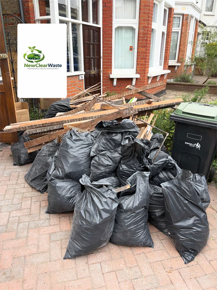 Timber and bagged waste ready for collection from a front drive