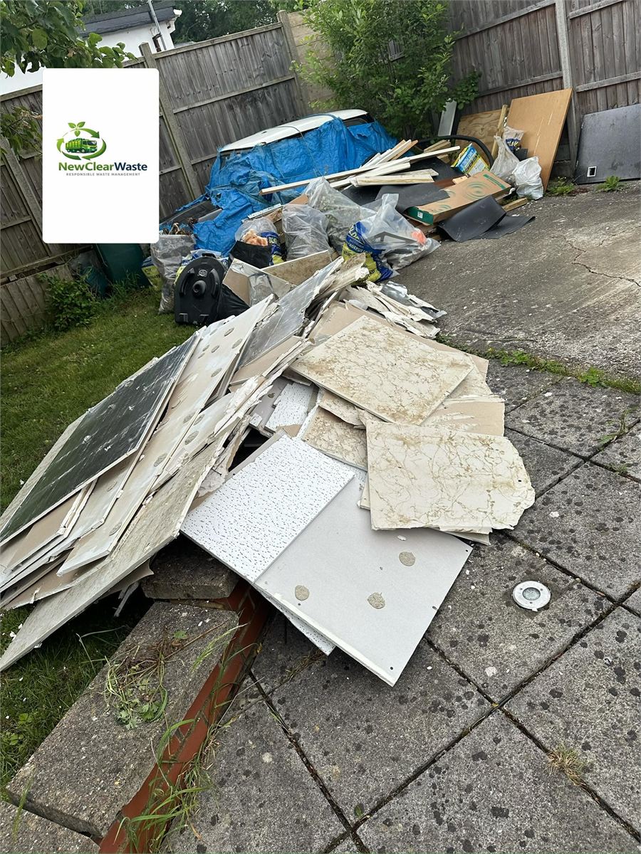Garden and hardstanding covered with boards and renovation waste before collection