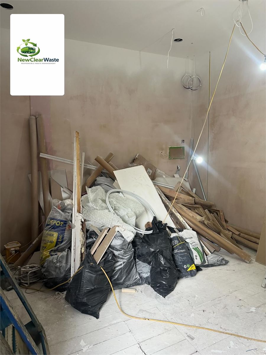Renovation room piled with boards, rubble bags and fittings before removal