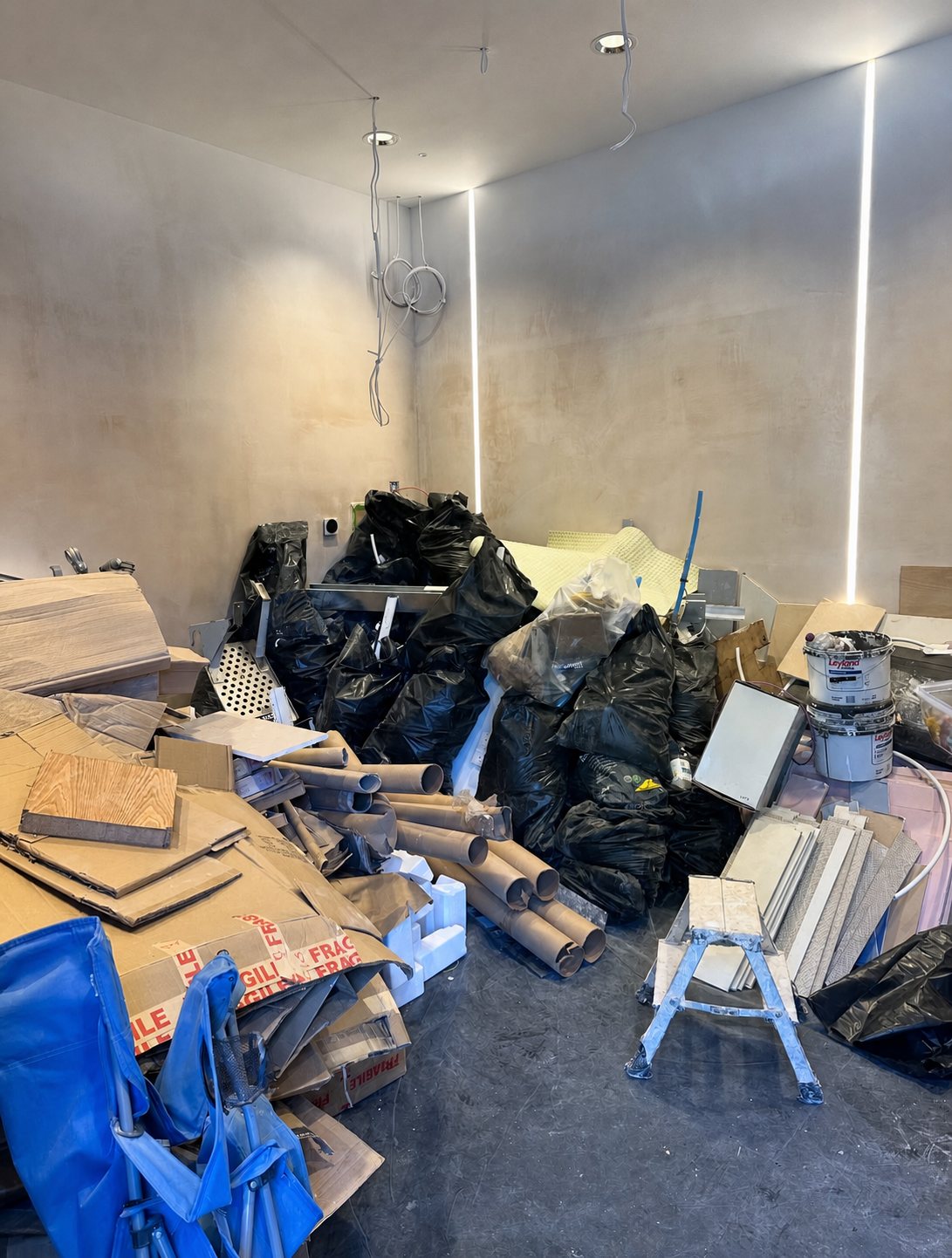 Renovation room filled with bags, boards, packaging and offcuts before clearance